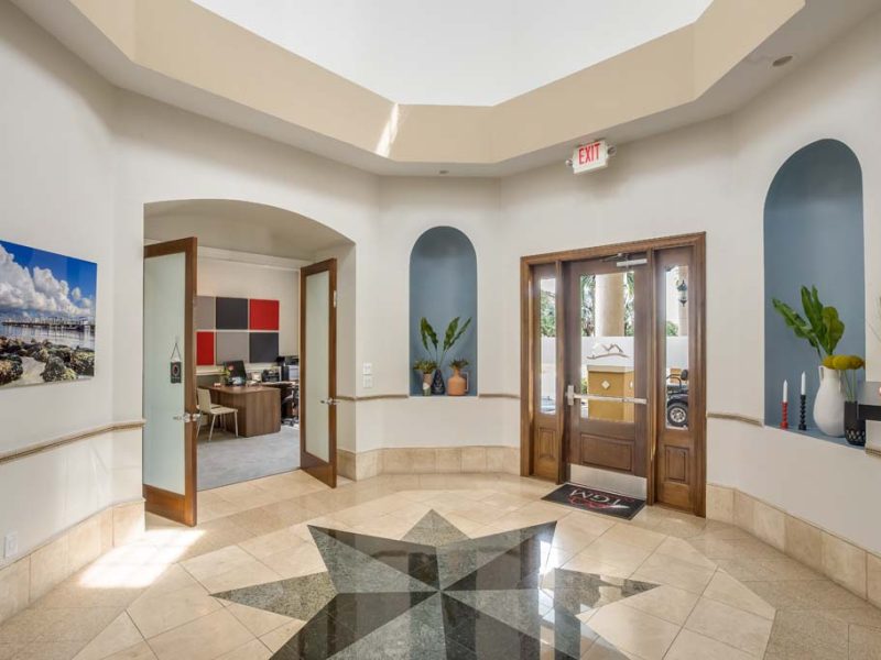 "This image shows the exit area of the ultimate luxury café lounge of the TGM Malibu Lakes Apartment. It also features the elegant style of the floor with welcoming painting and flowers around. "