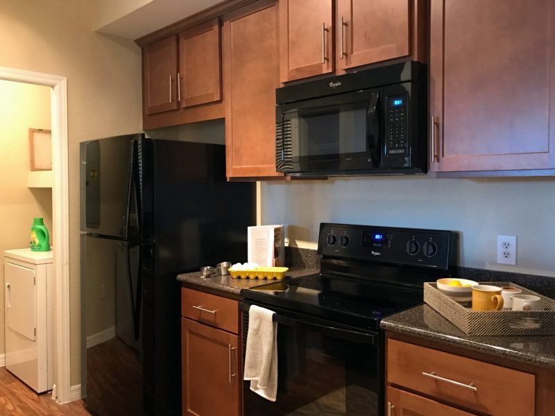 This image shows the Kitchen Island featuring the fully equipped gourmet-inspired kitchen with pantry, breakfast bar with the ideal trendy vinyl plank flooring, and brushed nickel fixtures.