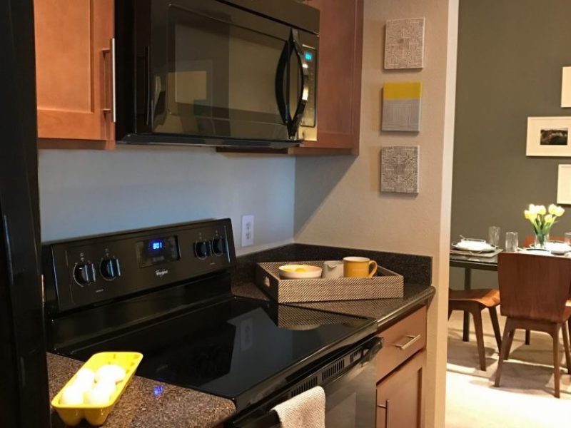 This image shows the Premium Apartment Featuring the fully equipped gourmet-inspired kitchen with pantry and breakfast bar with the ideal trendy vinyl plank flooring.