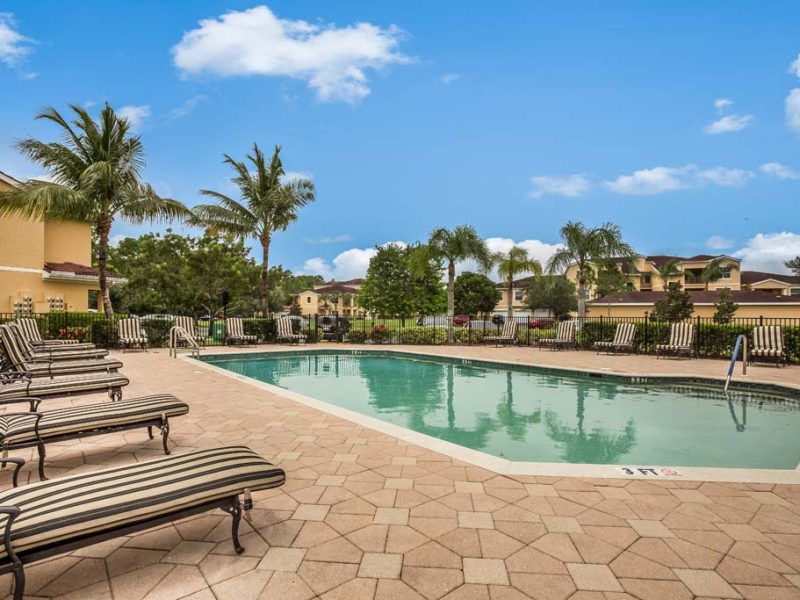 This image shows the resort-style outdoor swimming pool with a glittering sky blue water and pool beds for a lush tropical atmosphere for fun water experience.