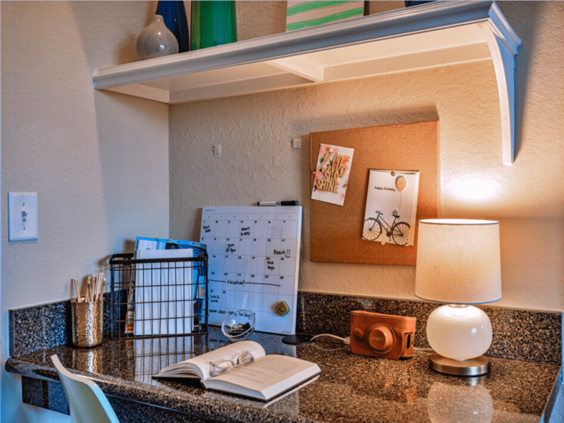 This image shows a unique style workspace with a lamp, gourmet table, and a wooden board.